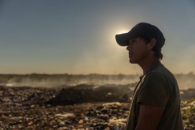 Boy at rubbish dump looking into the distance