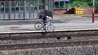 Teenager throwing bike onto railway line