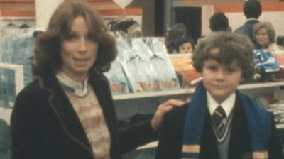 A BBC presenter with a schoolboy, discussing the cost of a school uniform
