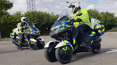 Police officers ride petrol-electric hybrid motorcycles