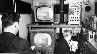 Two engineers looking at various monitors and equipment