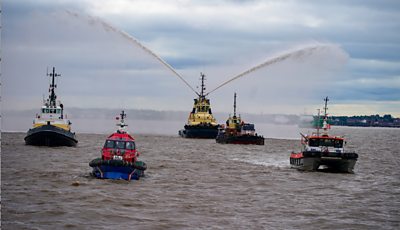 River tugs perform Fleur De Lis, (spraying of water from their fire cannons)