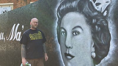 Artist David Brown in front of mural
