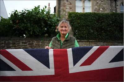 woman standing behind Union flag