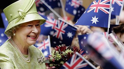 Queen Elizabeth II greeting people waving Australian flags.