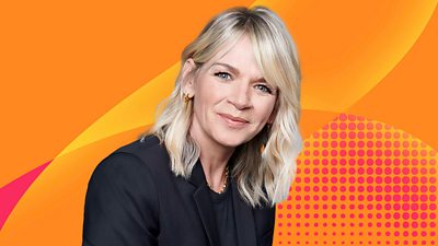 Zoe Ball's head and shoulders, set side on. She smiles for the camera, waring a black top and jacket, against a bright orange Radio 2 background.