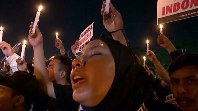 People singing and holding candles at the vigil