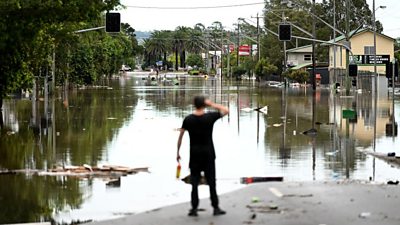 Man looks at flooded lismore street