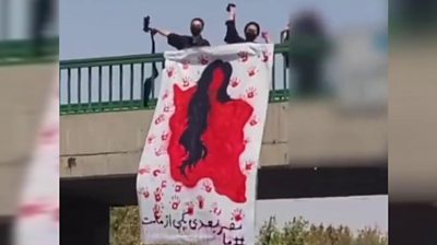Women in Iran hanging image of Iran as a blood-soaked woman