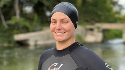 Elle English in a wetsuit next to a river