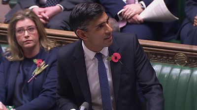 Rishi Sunak speaking in the House of Commons wearing a poppy