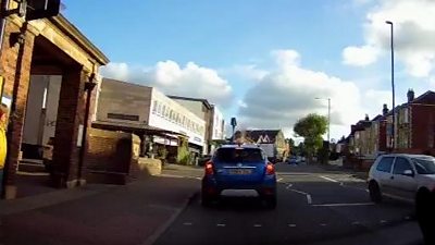 Image of a car driving down a road