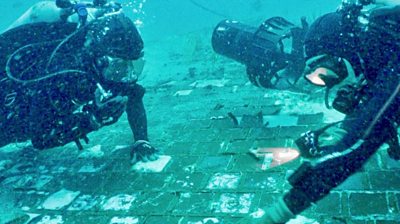 Two divers discovering the debris under water