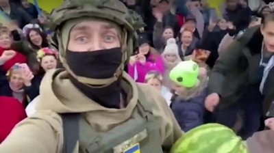 Soldier holding a watermelon in a crowd