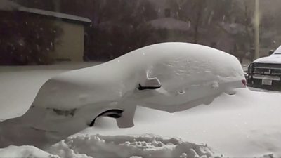 Snow covers parked car