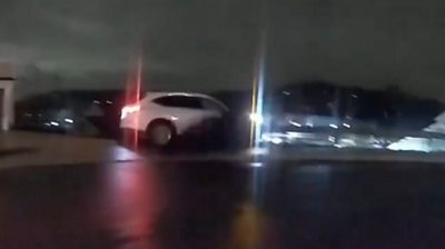 Car about to fall off a wall