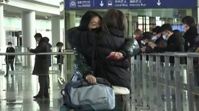Traveller from Hong Kong hugs person meeting her in arrivals.