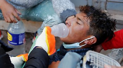 Young man lying on the floor with an oxygen mask over his mouth