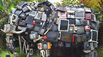 A collection of old audio/video equipment shaped into the suulpture of an elephant.