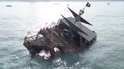 Pirate-themed restaurant on its side in the middle of the sea