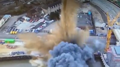 Aerial footage shows the moment of explosion, with smoke and debris rising high into the air.