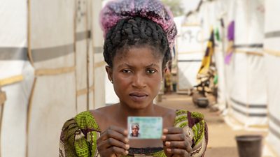 An internally displaced woman holding her ID