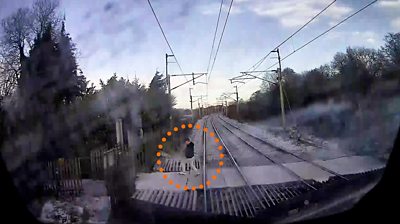 The pedestrian ignored a red warning light and came within feet of being hit by a high-speed train.