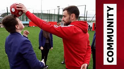 Bruno Fernandes teaches a pupil how to head the ball