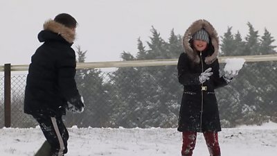 Two children enjoy a snowball fight