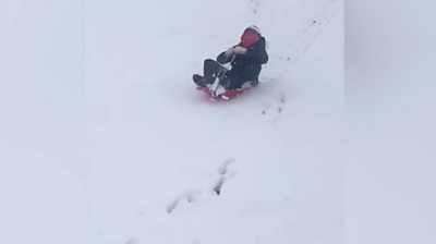 Child sledging in the snow