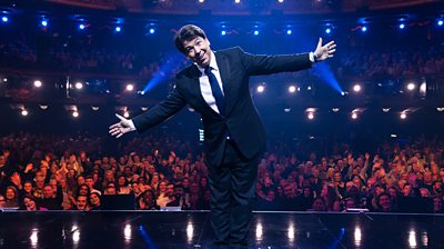 Michael McIntyre on stage in front of a huge audience