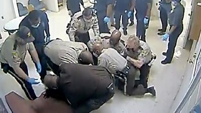 Otieno pinned down by officers and medical staff