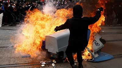 Protesters against Macron's pension reform set bins alight after two weeks of rubbish strikes.