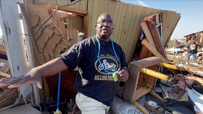 A survivor of the Mississippi tornado stands in the rubble of his destroyed home