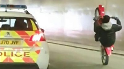Footage shows a biker driving dangerously in Leeds alongside a police car.