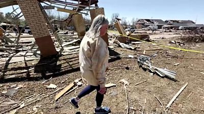 Teacher walks through rubble