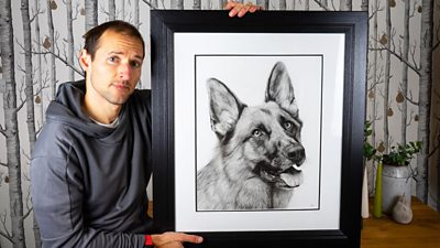 Artist Stuart Scott holding one of his pet portraits