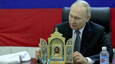 Russian President Vladimir Putin presenting an Orthodox icon to Russian troops