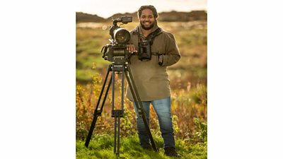 Hamza Yassin stands by his camera in the outdoors