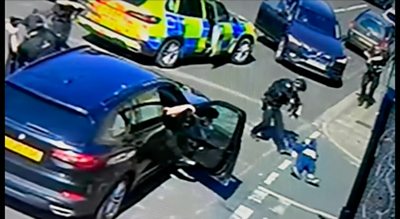 Armed officers approaching man on ground