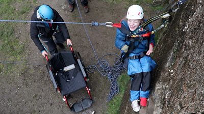 Inclusive climbing, Chloe is suspended by ropes and a harness as she is lowered into her wheelchair