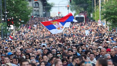 Serbian flag waves amongst crowd of protesters