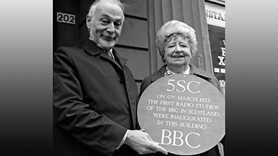 The BBC 5SC plaque presented by two veterans outside the original BBC Scotland offices.