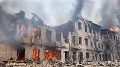 Fire burns out of damaged building in Dnipro, Ukraine.