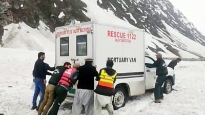 Men pushing a mortuary van in the snow