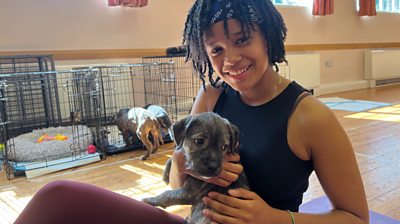 A women cuddling a puppy