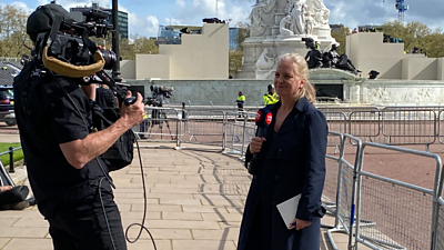 Woman presenting outside Buckingham Palace