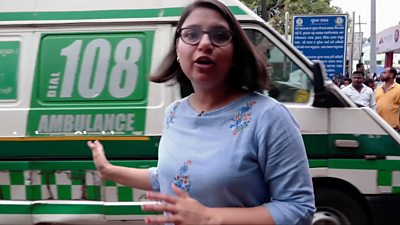 BBC correspondent Archana Shukla in front of an ambulance