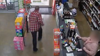 Man runs towards store exit while attendant sits at register