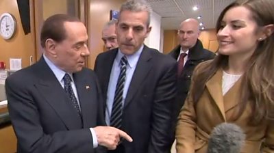 Silvio Berlusconi pointing at reporter Sofia Bettiza's hand